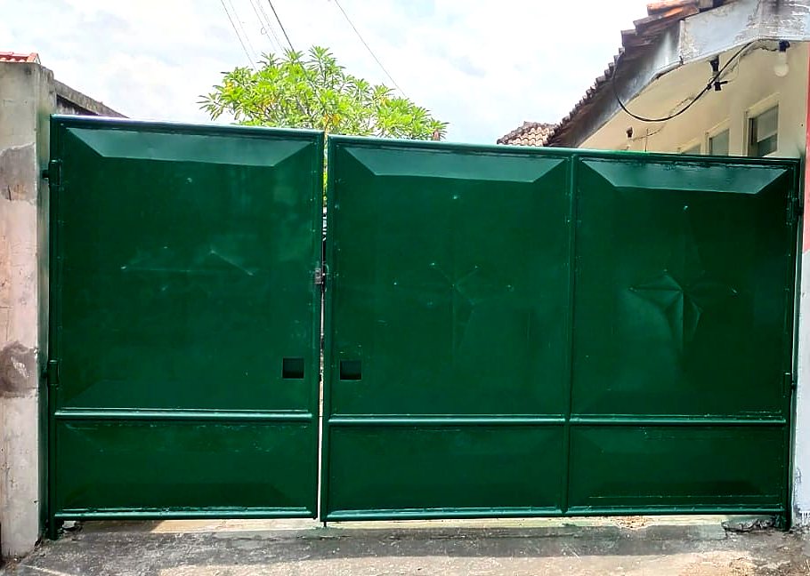 Pagar hijau besar sebagai patokan pintu masuk kos